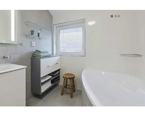 Koupelna s umyvadlem, zrcadlem, skříňkami, policemi, oknem, žaluziemi, stoličkou a vanou.