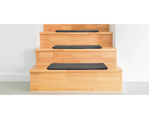 Dřevěné schodiště s tmavými stupnicovými rohožemi