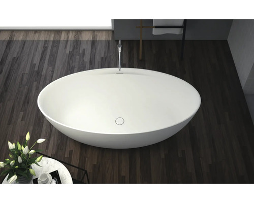 Volně stojící vana v koupelně s dřevěnou podlahou.