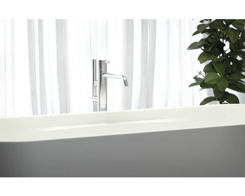 Volně stojící vana s baterií před oknem