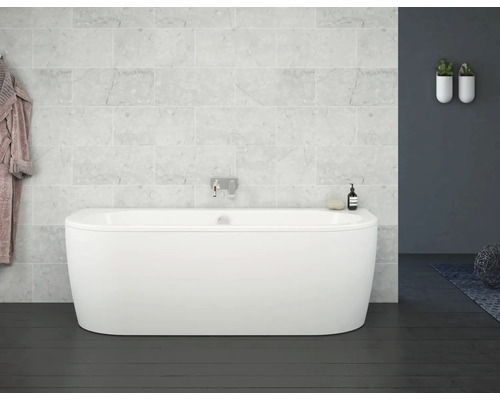 Volně stojící vana v koupelně se světlými mramorovými obklady