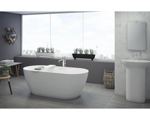 Moderní koupelna s volně stojící vanou, umyvadlem a dekorativními prvky pro světlou a přátelskou atmosféru.