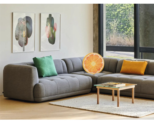 Obývací pokoj s šedou rohovou pohovkou, polštáři a konferenčním stolkem