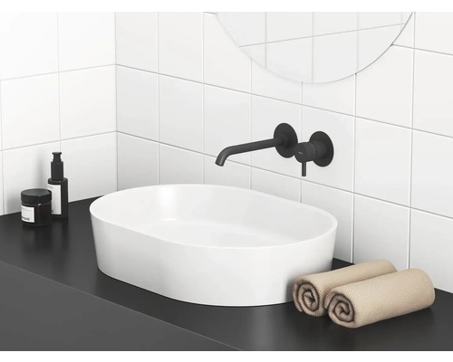 Moderní koupelna s umyvadlem na desku, baterií a ručníky