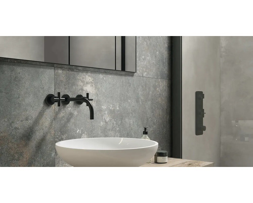 Moderní koupelna s umyvadlem, vodovodní baterií, zrcadlem a šedými obklady.