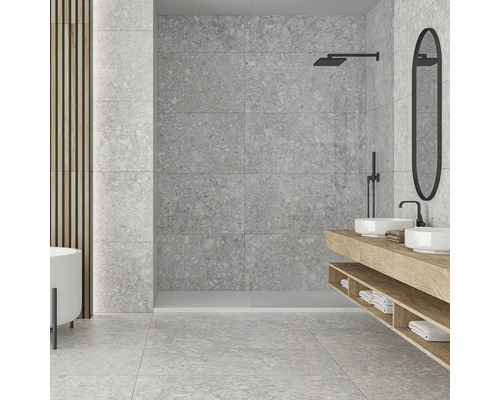 Světlá koupelna se šedými obklady, umyvadlem, zrcadlem a sprchou