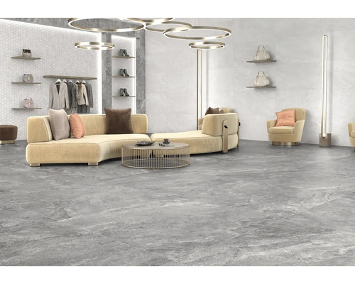 Světlá místnost s podlahovými dlaždicemi s kamenným vzhledem, pohovka, křeslo a dekorace