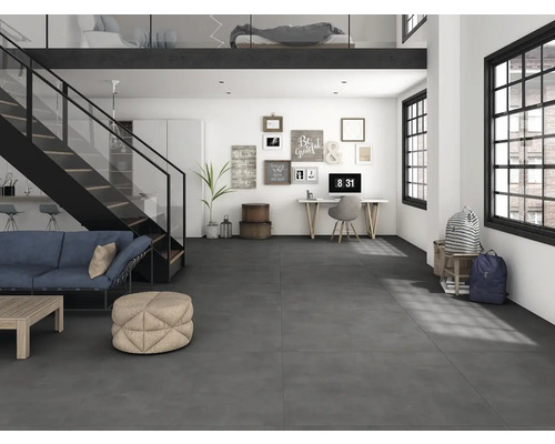 Světlá místnost se schodištěm, pohovkou, stolem a tmavou podlahou