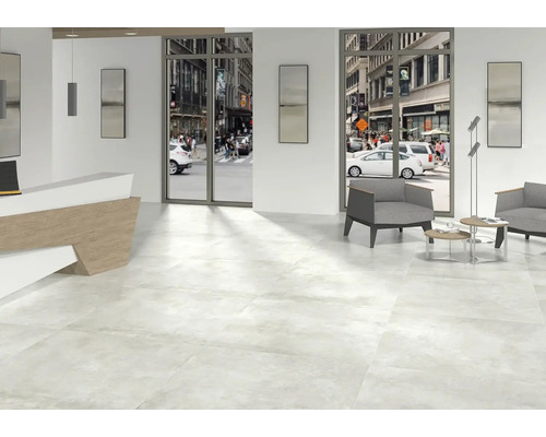 Světlá místnost s dlažbou, recepcí a posezením s výhledem na ulici