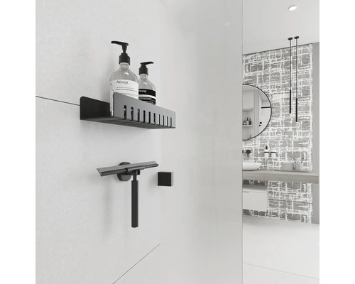 Moderní koupelna s policí, stěrkou na sprchy a dekorativní stěnou.