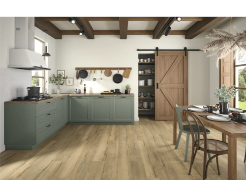 Světlá a prostorná kuchyně se zelenými skříněmi, dřevěnou podlahou a dřevěným stolem