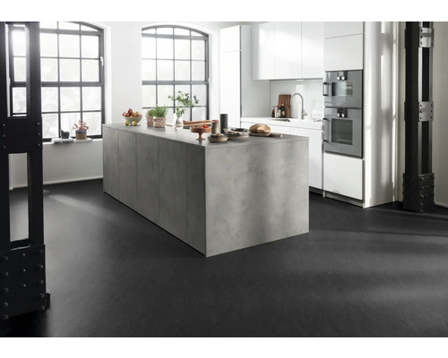 Světlá kuchyně s kuchyňským ostrovem, bílými skříňkami a černou podlahou.