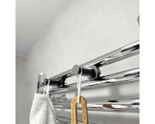 Otopný žebřík s ručníkem a kartáčem v koupelně