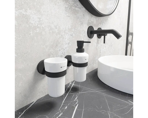 Koupelnový prostor umyvadla s černou armaturou, bílým umyvadlem na desku, kelímkem na zubní kartáčky a dávkovačem mýdla