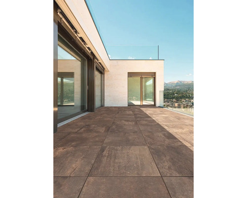 Terasa s hnědými dlaždicemi a skleněným zábradlím za slunného dne