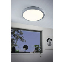 Kulaté stropní svítidlo v moderním pokoji s oknem.