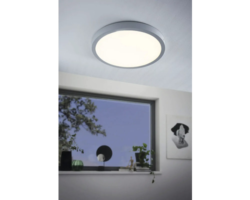 Kulaté stropní svítidlo v moderním pokoji s oknem.