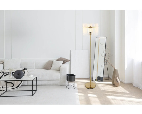 Světlý obývací pokoj s pohovkou, stojací lampou a zrcadlem