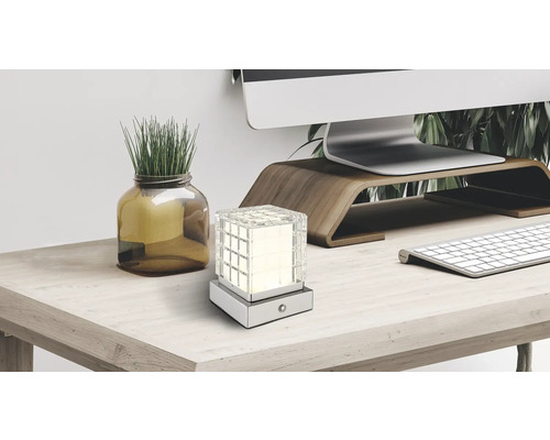 Stolní lampa se skleněnou kostkou na psacím stole s počítačem, klávesnicí a dekorací.