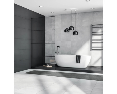 Moderní koupelna s volně stojící vanou, tmavou akcentní stěnou a stylovým osvětlením.