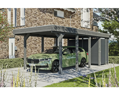 Přístřešek na auto SKAN HOLZ Friesland-Hybrid vč. hliníkového úložného prostoru, 314 x 708 cm břidlice Dřevěný přístřešek pro auto s úložným prostorem vedle domu s cihlovými zdmi a zeleným autem