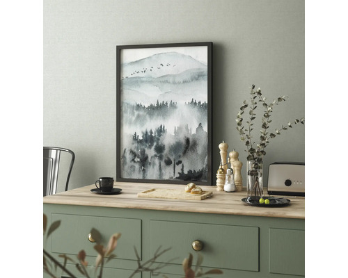 Zarámovaný obraz s akvarelem horské krajiny na stole