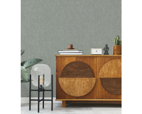 Obývací pokoj s tapetou se vzorem, příborníkem a dekorativními prvky.