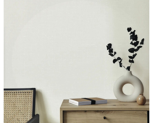 Světlá místnost s komodou, vázou s rostlinami, zápisníky a židlí