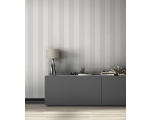 Obývací pokoj s pruhovanou tapetou, příborníkem a stolní lampou