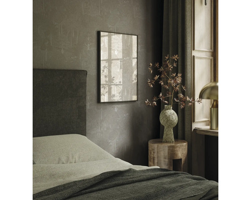 Ložnice s postelí, nočním stolkem a zarámovaným obrazem na zdi