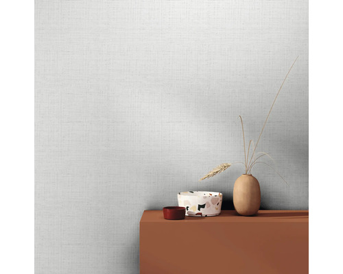 Světlá tapeta s lněnou strukturou a dekorativními předměty