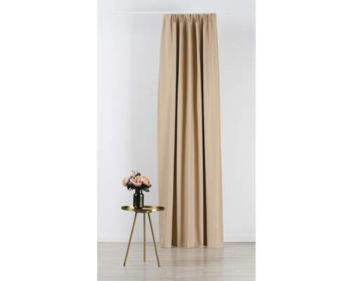 Béžový závěs vedle malého stolku s květinovou vázou