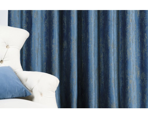 Dekorativní modrý závěs s vertikálním vzorem vedle křesla.
