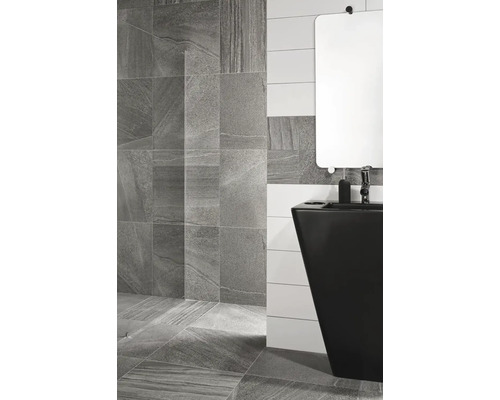 Koupelna s šedými dlaždicemi na podlaze a stěně a černým umyvadlem