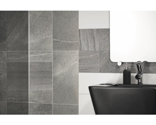 Moderní koupelna s šedými obklady, černým umyvadlem a zrcadlem