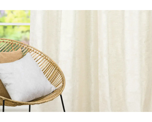 Interiérová scéna s ozdobnými šálami a ratanovým křeslem.