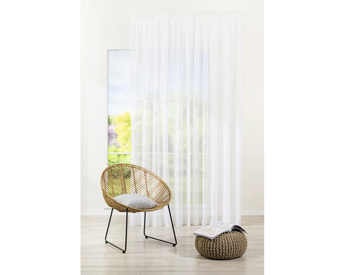 Světlá místnost s oknem, závěsem, křeslem a stoličkou