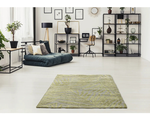 Obývací pokoj s vzorovaným kobercem, rozkládací pohovkou a regály