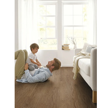 Otec a dítě si hrají na dřevěné podlaze v světlém obývacím pokoji.