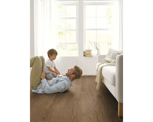 Otec a dítě si hrají na dřevěné podlaze v světlém obývacím pokoji.
