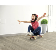 Dívka s helmou a skateboardem na světlé dřevěné podlaze