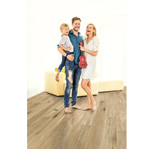 Rodina s dítětem a červeným ukulele na dřevěné podlaze ve světlé místnosti