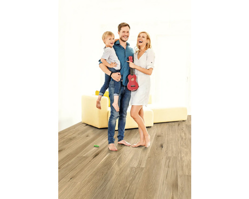 Rodina s dítětem a červeným ukulele na dřevěné podlaze ve světlé místnosti