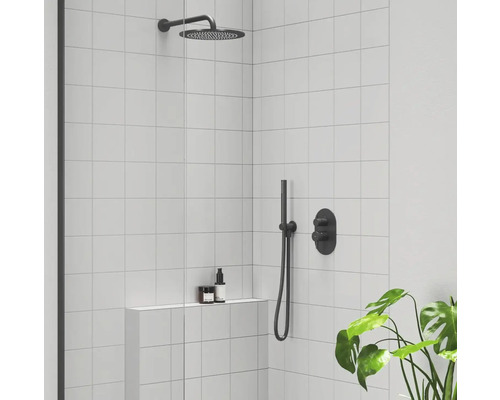 Sprchový kout se stropní sprchou, ruční sprchou a baterií před stěnou s bílými obklady