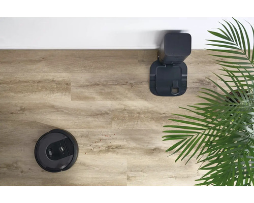 Robotický vysavač s nabíjecí stanicí na dřevěné podlaze