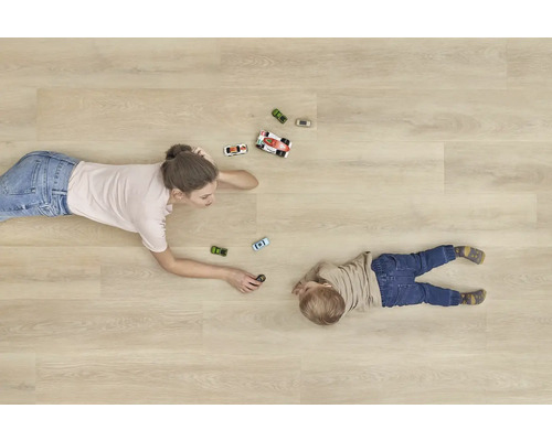 Žena a dítě si hrají s autíčky na dřevěné podlaze.