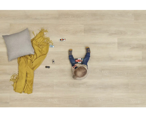 Dítě si hraje na podlaze s polštářem, dekou a autíčky