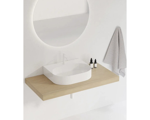 Moderní koupelna s kulatým zrcadlem, umyvadlem a ručníkem