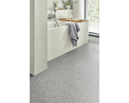 Moderní koupelna s vanou, ručníkem a strukturovanou podlahovou krytinou