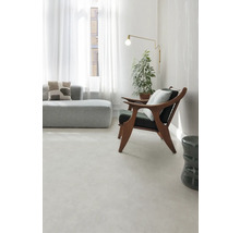 Světlý obývací pokoj s pohovkou, křeslem, stojací lampou a pokojovou rostlinou